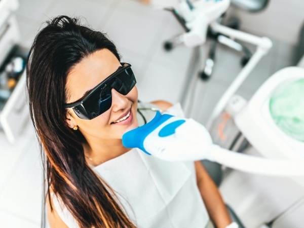 Woman receiving in office teeth whitening treatment