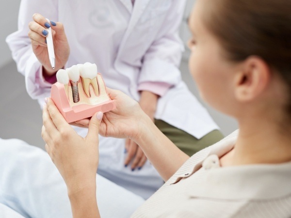 Dentist and dental patient discussing the four step dental implant process