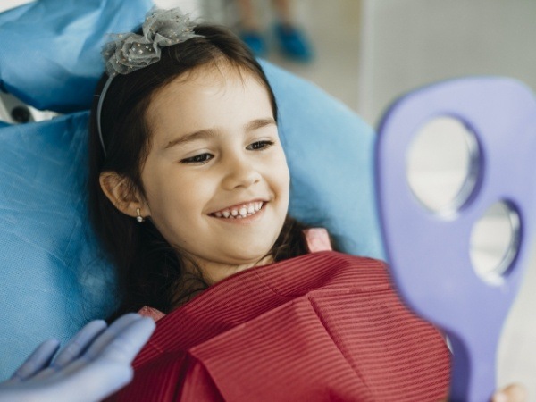 Child looking at smile during children's dentistry visit