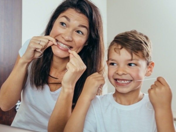 Mother and child flossing together