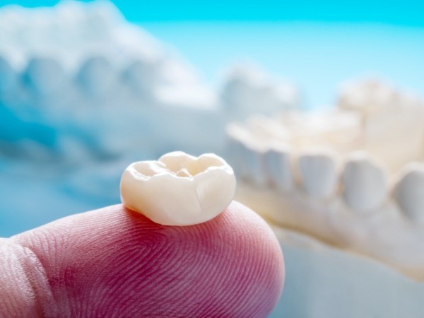 Dental crown restorative dentistry restoration on fingertip