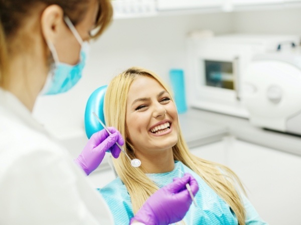 Woman smiling during dental checkup and teeth cleaning visit