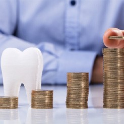 Coins being stacked next to a tooth