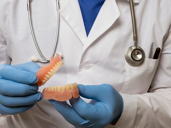 Dentist holding a set of full dentures in Brookfield