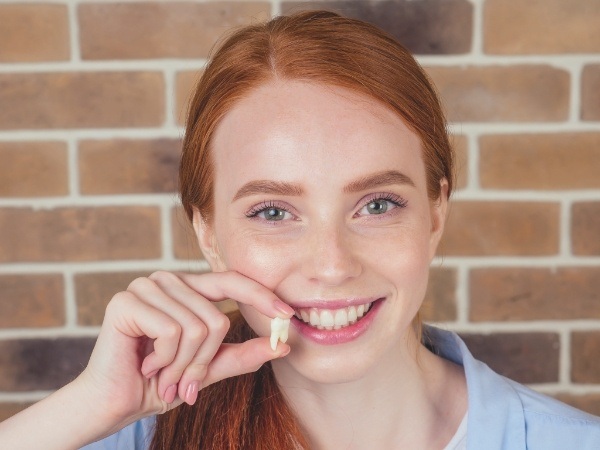 Person holding extracted tooth