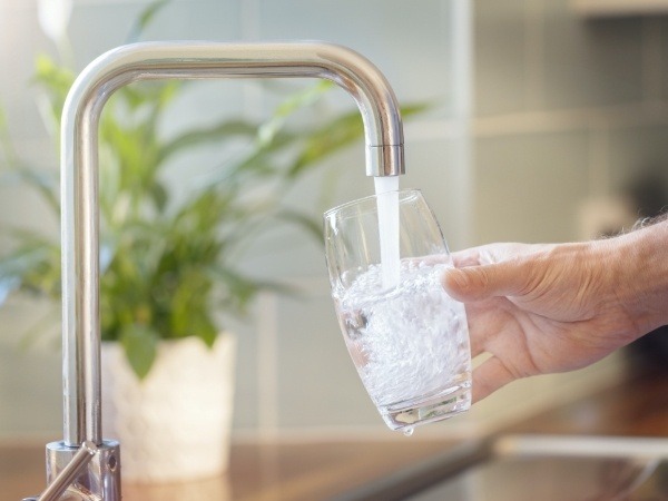 Person pouring a glass of water