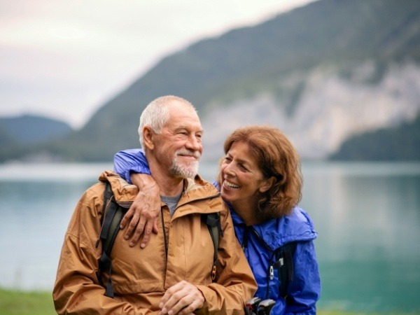 Man and woman smiling together after dental implant tooth replacement