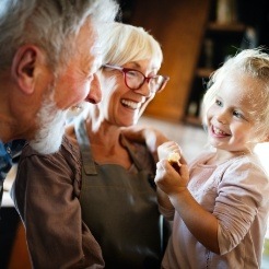 Older couple and young child smiling together