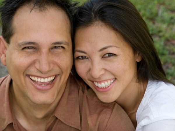 Man and woman with dental implants smiling
