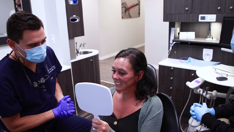 Brookfield dental patient looking at her new smile in a mirror