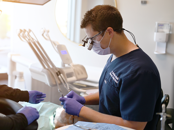 Dentist talking to young dental patient and parent