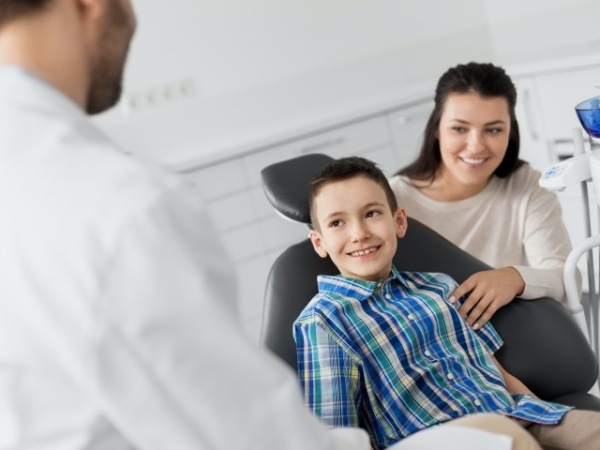 Dentist talking to young dental patient and parent