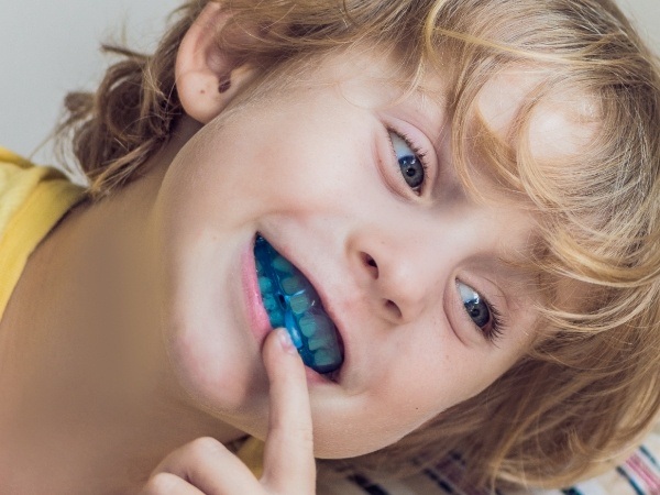 Child pointing to myofunctional therapy appliance