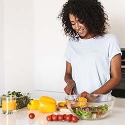 Smiling woman making healthy meal in white kitchen