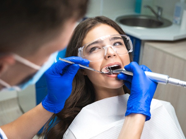 A dentist performing a root canal on a woman