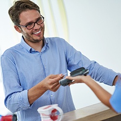 A man paying the cost of veneers in Brookfield