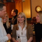 Four people standing and talking at a party