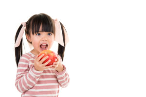 little girl holding an apple