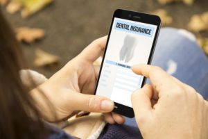 Person using phone to learn about dental insurance benefits