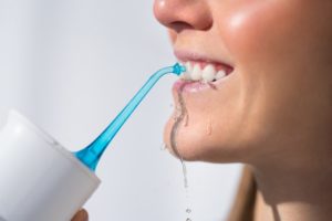 woman using oral irrigator 