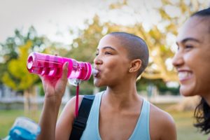 woman drinking water after workout