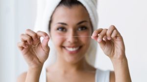 Closeup of a patient holding dental floss.