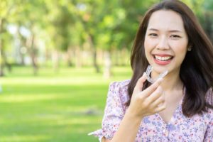 Woman smiling and removing her Invisalign clear aligner.