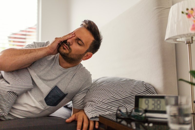 man rubbing his eyes just after waking up