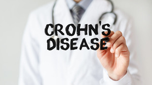 Doctor writing the words “Crohn’s Disease” in marker