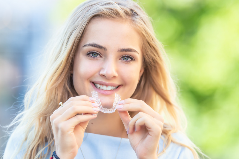 Patient putting in their Invisalign aligners